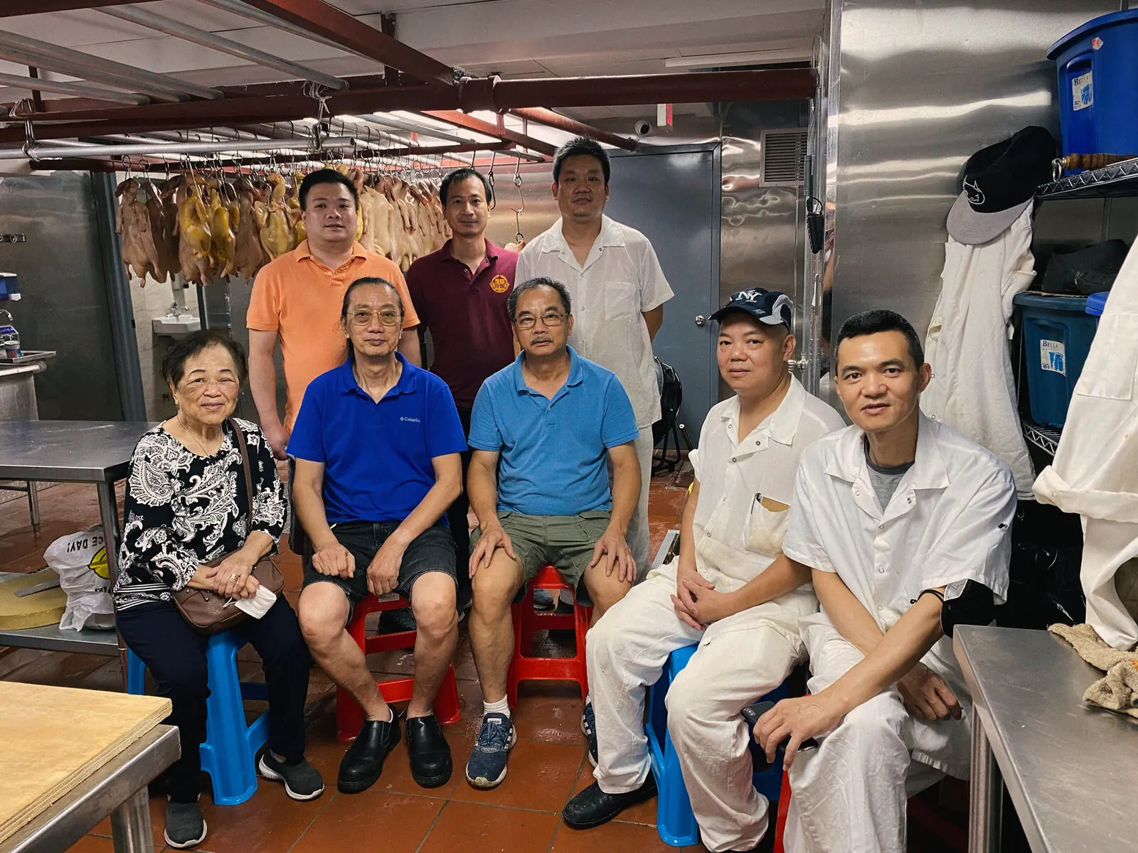 The Noodletown crew in the kitchen under the hanging ducks