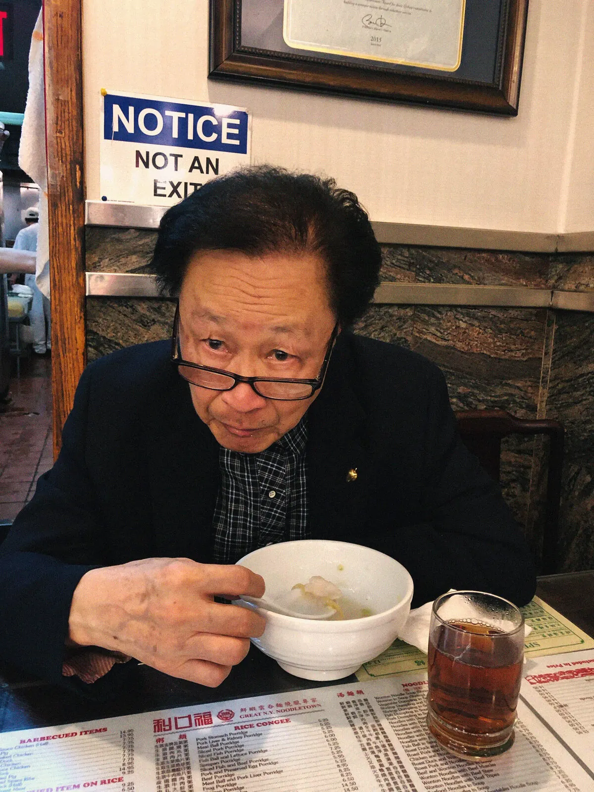 A diner with a bowl of congee at a Noodletown table
